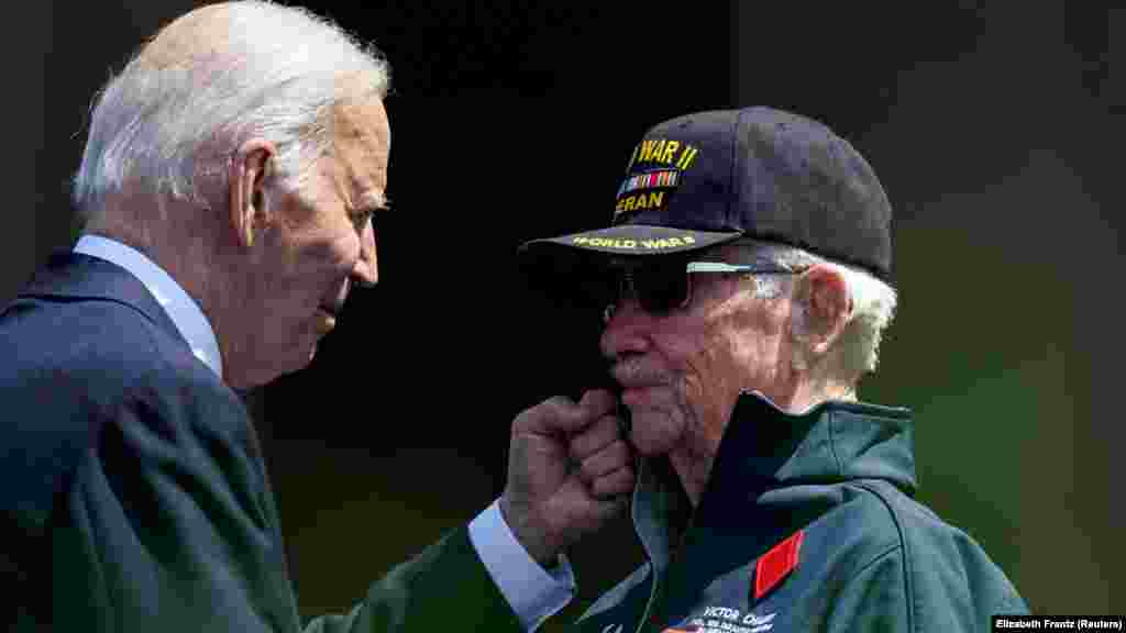 Байден показує жест сили ветеранові Другої світової війни, який брав участь у штурмі пляжів Нормандії 6 червня 1944 року. «День Д» був найбільшим десантним штурмом в історії, і Байден назвав його «потужною ілюстрацією того, як альянси, справжні альянси, роблять нас сильнішими». Він сказав, що це «урок, який, я молюся, щоб ми, американці, ніколи не забули»  
