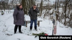 Бучанка Світлана Сафонова на могилі сестри Ірини Філкиної, яку, за словами свідків, російські окупанти застрелили, коли вона їхала додому на велосипеді. Фото руки Ірини із манікюрюм, який вона зробили напередодні загибелі, облетіло весь віт