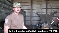 Микола, командир ремонтного взводу, біля двигуна від американської вантажівки