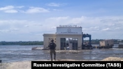 Un ofițer al Comitetului rus de Investigații lângă barajul Kahovka distrus. Iunie 2023