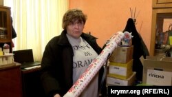 Надія Жур показує один із лотів для волонтерської лотереї (розмальований тубус від використаного гранатомета)