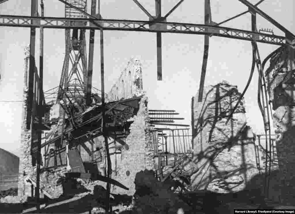 Здания угольной шахты, которые были "разрушены гитлеровцами" во время отступления немецких войск, как следует из подписи к ней. С 2014 года Донбасс оказался вновь охвачен военным конфликтом после того, как Кремль поддержал местных сепаратистов, требовавших независимости от Украины. Этот конфликт продолжался 8 лет, пока не перерос в развязанную Россией полномасштабную войну.