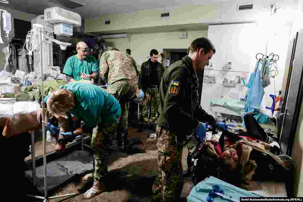 Медики Збройних сил України допомагають не лише військовим, а й усім, хто потребує медичної допомоги. Праворуч на фото видно жінку, яку придавило уламками будівлі внаслідок бойових дій у Бахмуті. Українські медики врятували її, надавши першу необхідну допомогу. Бахмутський стабпункт, листопад 2022 року 