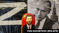 Російська матрьошка з портретом голови Китаю Сі Цзіньпіна перед фотографією очільника Росії Володимира Путіна у сувенірній вуличній крамниці в центрі Москви, 20 березня 2023 року (ілюстраційна світлина)