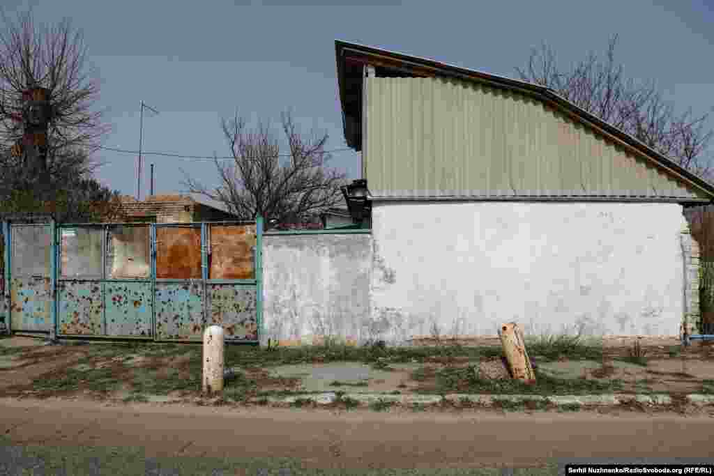 Українські військові розмовляють у нещодавно звільненому селі Лук'янівка Київської області, березень 2022 року / На фото праворуч це ж місце у березні 2024 року