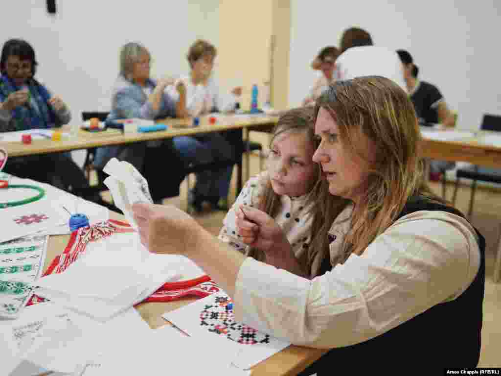 Жителька Праги Тереза вчиться українській техніці вишивання разом зі своєю дочкою Аріаною під час уроку в Празі. Чехія, 17 травня 2024 року