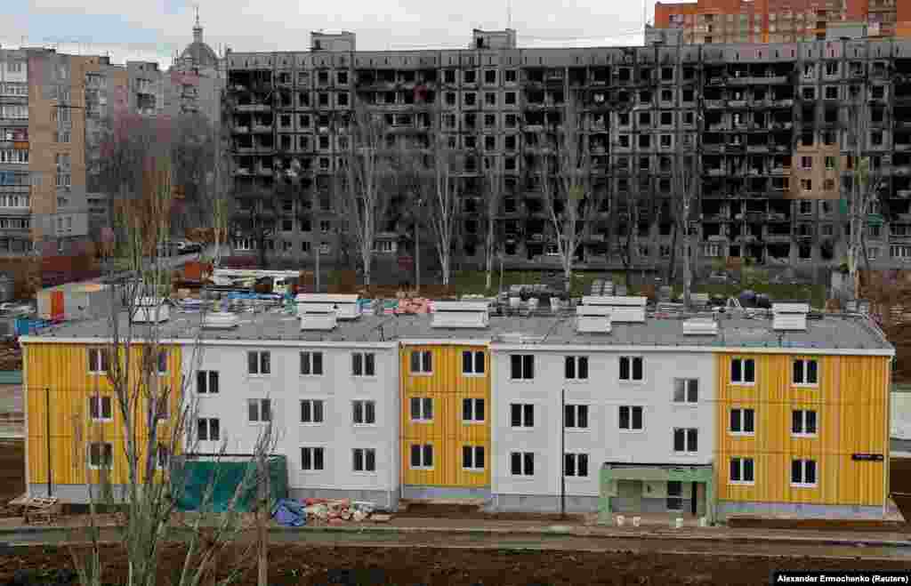 A new building in front of a war-ruined apartment block. Anti-Kremlin activist Aleksei Navalny’s investigative team has alleged that top Russian officials are profiting personally from reconstruction projects under way in Mariupol.  