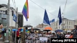 Колона із військових ЗСУ на Марші рівності тримає плакат із фотографіями загиблих на війні представників ЛГБТК+ спільноти, Київ, 16 червня 2024 року