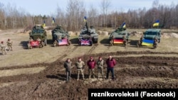 Міністр оборони Олексій Резніков (посередині) перед отриманою від західних партнерів технікою – танком Challenger від Британії, бронетранспортерами Stryker і Cougar від США та БМП Marder від Німеччини, 27 березня 2023 року