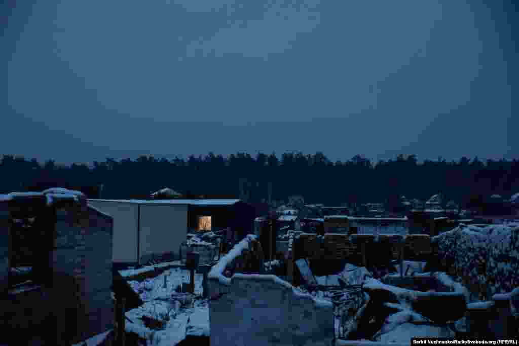 Мощун накривають вечірні сутінки. Серед руїн де-не-де, у маленьких вікнах модульних будинків загоряється світло 