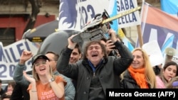 Кандидат в президенты Хавьер Милей с бензопилой между своей сестрой Кариной Милей и кандидатом в губернаторы провинции Буэнос-Айрес Каролиной Пипаро на митинге. Сентябрь 2023 года