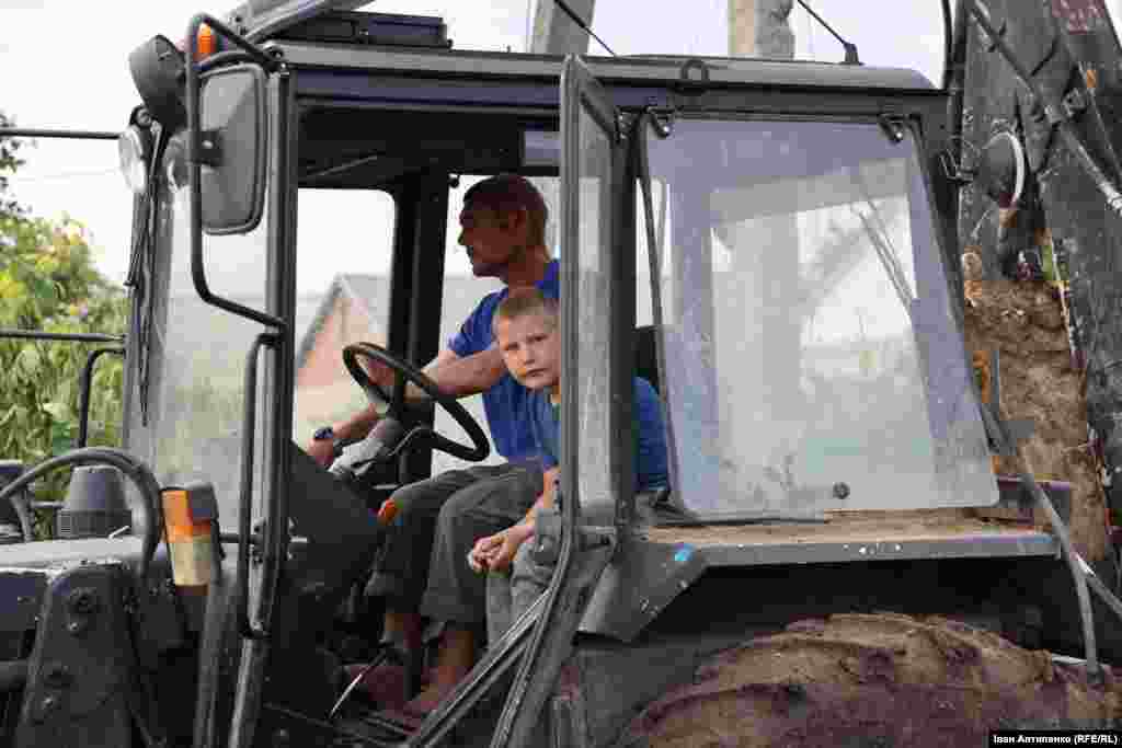 Молодший син Альони – десятирічний Толя сидить у кабіні із сусідом, який керує трактором. Він допомагає розбирати завали свого будинку