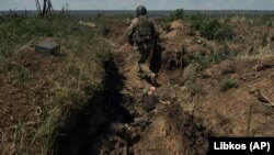 Український військовий йде в нещодавно захопленому російському окопі поблизу Бахмута, 4 липня 2023 року