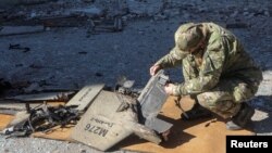 Ілюстраційне фото. Офіцер поліції оглядає уламки ударного дрона з маркуванням «Герань-2» у Харкові, жовтень 2022 року