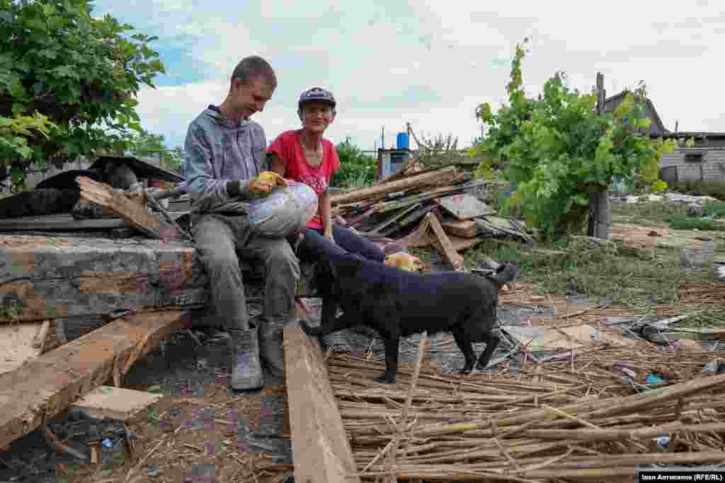 Альона і її син Євген (13 років) з селища Білозерка біля свого зруйнованого затопленням будинку. Вони попросили сусіда допомогти вигребти трактором залишки стін із подвір’я. Наразі родина живе у кумів
