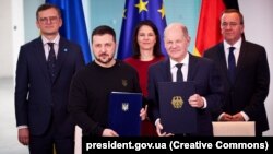 Президент України Володимир Зеленський і канцлер Німеччини Олаф Шольц (праворуч) під час церемонії підписання безпекової угоди. Берлін, 16 лютого 2024 року