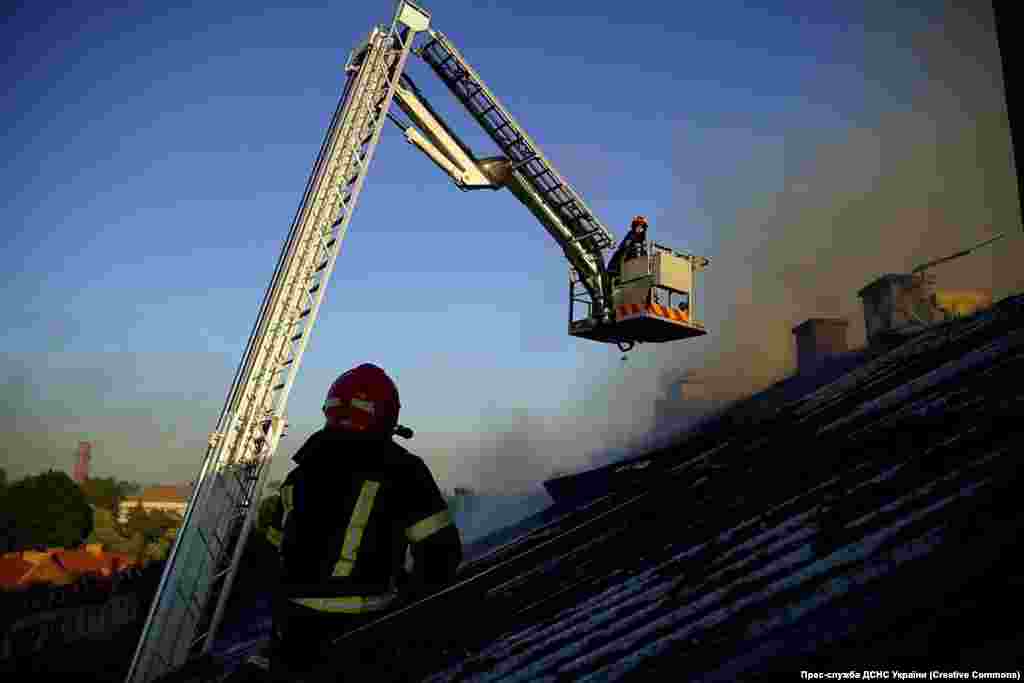 Працівники ДСНС гасять пожежу, що виникла в одному з житлових будинків після російського ракетного обстрілу Львова, 15 серпня 2023 року