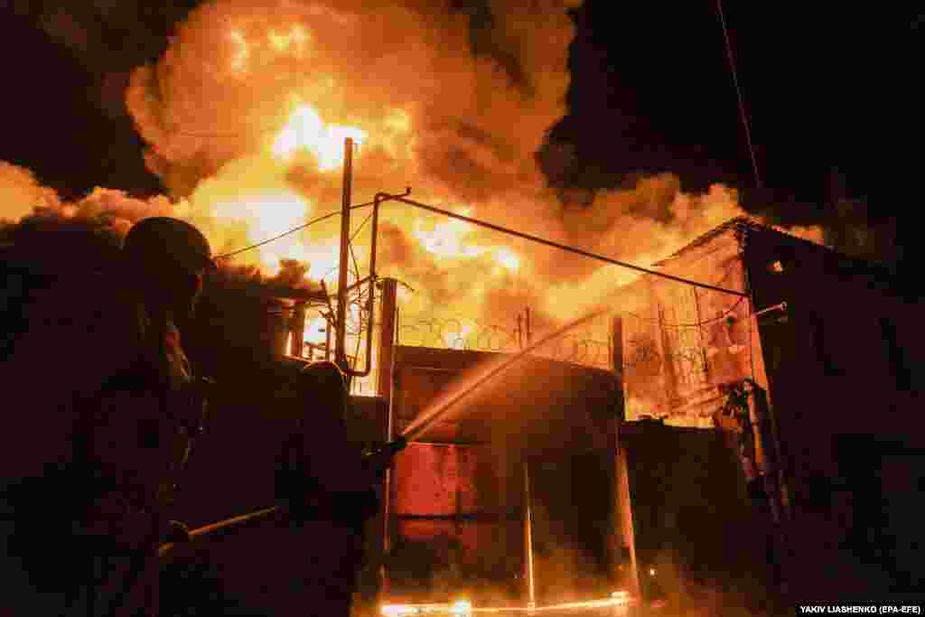 Вогнеборці намагаються загасити вогонь, який виник в результаті атаки російських дронів. Харків, 4 травня 2024 року  