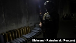 Український військовослужбовець стоїть в укритті біля артилерійських снарядів на передовій в Запорізькій області, 13 вересня 2023 року.