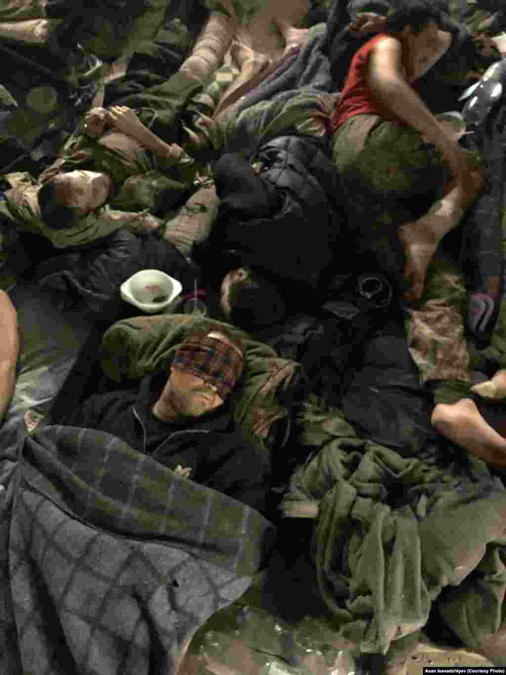 Військовий шпиталь в одному з бомбосховищ «Азовсталі». Асан розповідає, що іноді кількість поранених тут сягала пів тисячі: «Запах крові, ампутованих кінцівок, гною, калу, сечі, поту… І величезна вологість. Тому що, мінімум, 300 людей одночасно дихають в одному приміщенні у величезному підвалі»