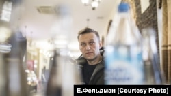 В придорожном кафе Навальный смотрит новости на включенном в зале телевизоре
