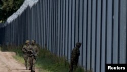 Польські солдати патрулюють вздовж прикордонного паркану на польсько-білоруському кордоні, Польща, 30 серпня 2023 року