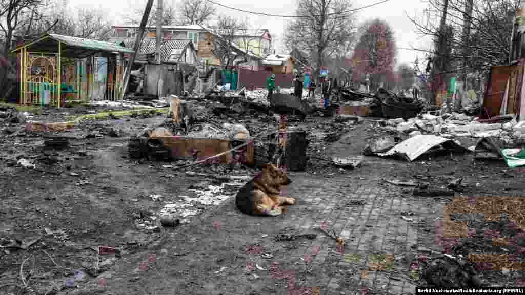 Вулиця Вокзальна і спалена техніка російської армії, місто Буча, Київської області, 1 березня 2022 року. На фото праворуч – вулиця Вокзальна у травні 2023 року