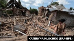 Місцева жителька Олена оглядає уламки свого будинку після обстрілу в Оріхові, поблизу лінії фронту в Запорізькій області, 10 червня 2024 року