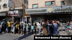 Civilii palestinieni așteaptă să cumpere pâine în localitatea Khan Younis. Două convoaie cu ajutoare au intrat până acum în Fâșia Gaza. 