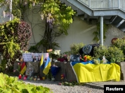 Люди несуть квіти і лампадки, вшановуючи пам'ять загиблих