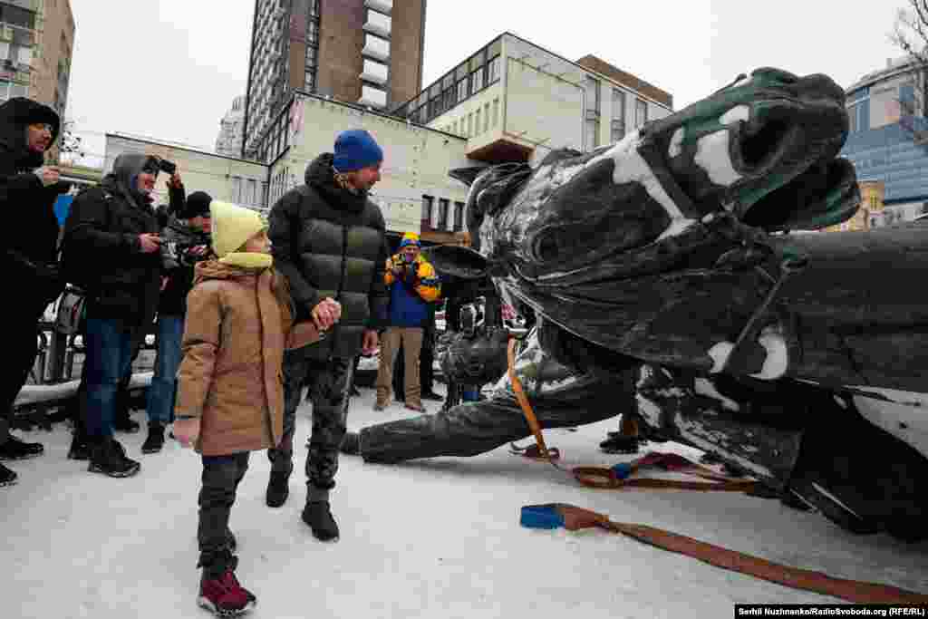 Батько показує дочці демонтований пам'ятник 