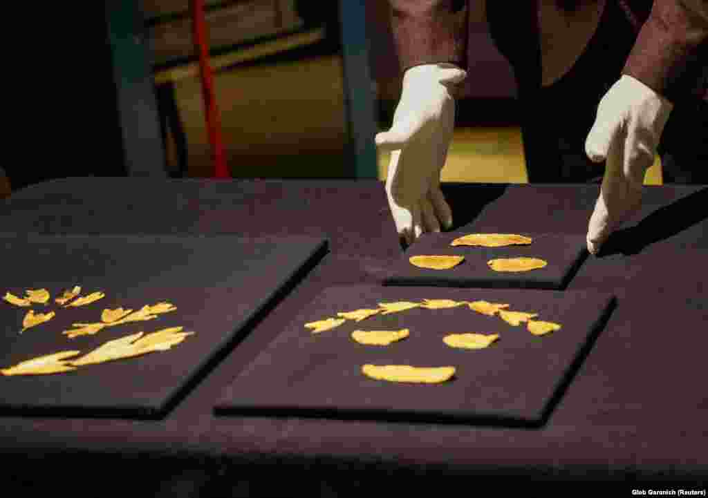 Эксперт Национального музея истории Украины демонстрирует старинные золотые артефакты. Представленные на выставке 2014 года под названием «Крым: золото и тайны Черного моря» в амстердамском музее Алларда Пирсона, артефакты были переданы в Киев по решению Верховного суда Нидерландов, принятому в июне