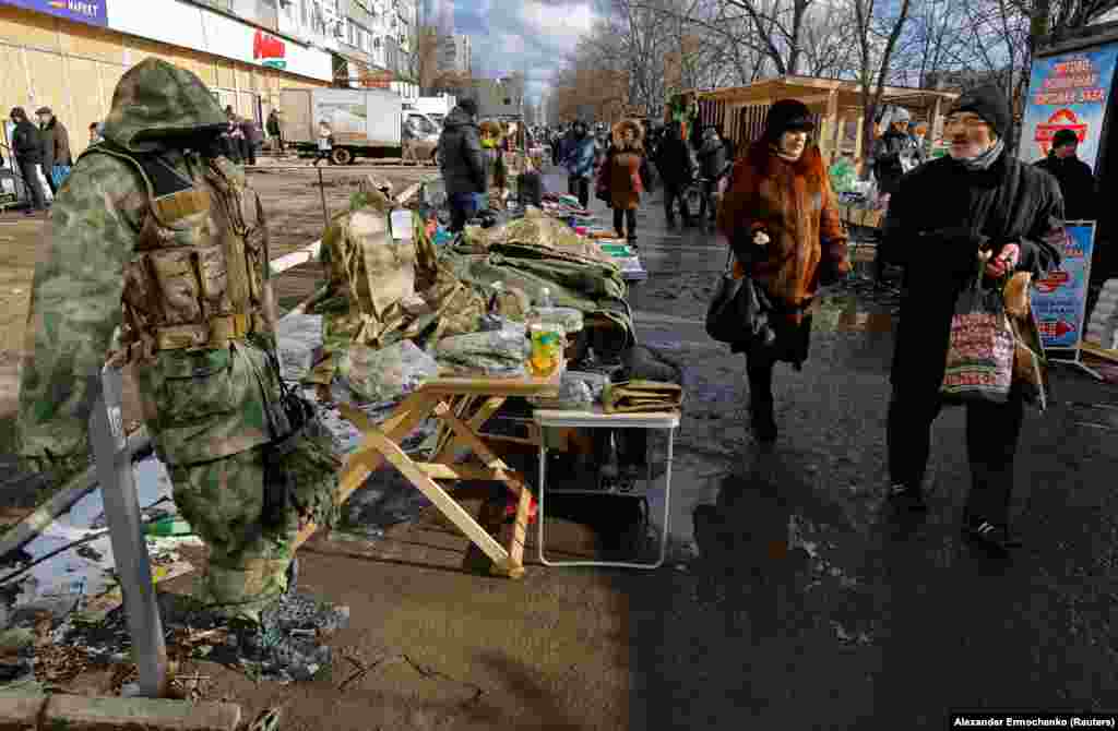 People shop at a makeshift market in Mariupol. 
