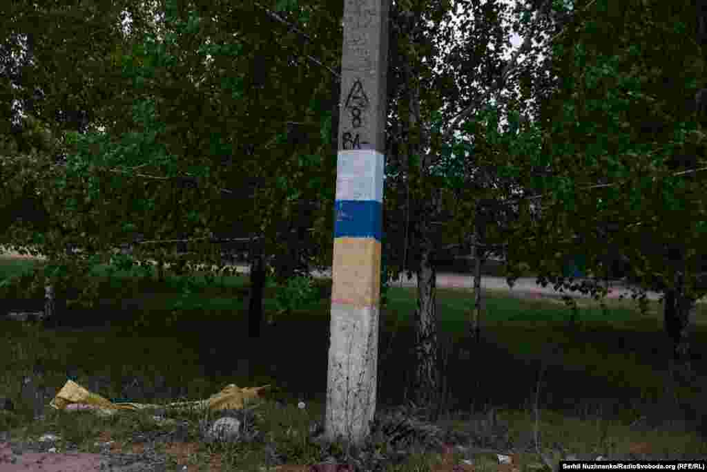 Зображення українського прапора намальовано на стовпі в деокупованому місті Борова, щоб знищити під собою сліди російського триколора. Харківщина, квітень 2024 року