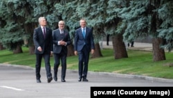 Președinții țărilor baltice - Gitanas Nausėda din Lituania (stânga), Alar Karis din Estonia și Edgars Rinkēvičs din Letonia - plimbându-se pe lângă un rând de pini din apropierea Casei Guvernului de la Chișinău, pe 27 august 2024