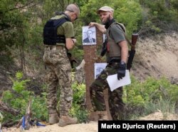 Бійці стрілецького батальйону «Карпатська Січ» готують мішені із зображенням президента Росії Володимира Путіна під час навчань для новобранців на стрільбищі в Харківській області, 30 червня 2022 року