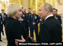 Президент Росії Володимир Путін поруч з Марією Костюк, матір'ю російського солдата, якого посмертно нагородили орденом «Герой Росії». Москва, 8 грудня 2023 року