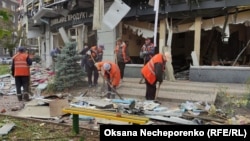 Комунальники Харкова прибирають вулицю після чергового російського ракетного удару, 6 жовтня 2023 року