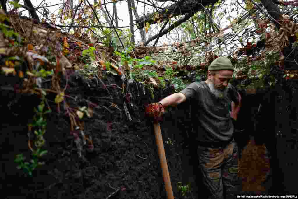 Анатолій – сильні руки, сива борода, важкі слова... До позицій супротивника декілька сотень метрів. «Цивільні забули про війну, усіх їх якось так підзаї**ла та війна. Приходить до моєї дружини сусід і жаліється, як його за**ала війна. Йому дружина відповідає: «Славіку, ти сидиш вдома, спиш в ліжку, в теплі, і вона тебе за**ала?». Їх уже всіх за**ало. Не знаю, що їм ще треба? Я був у відпустці, кав'ярні як були повні, так і є, хлопці молоді як сиділи там, так і сидять далі», – каже Анатолій, продовжуючи копати окоп Донеччина, жовтень 2023 року