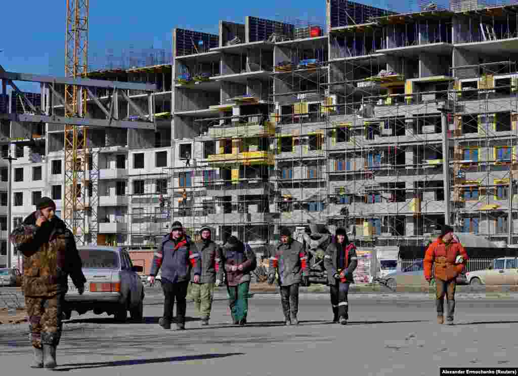 Workers at the site of a construction project in Mariupol. According to the UN, up to 90 percent of the city's residential buildings were damaged or destroyed during the Russian siege. 