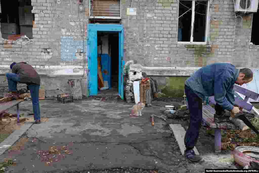 Біля одного зі зруйнованих будинків зустрічаємо місцевих жителів. Олександр і Раїса готують дрова для побутових потреб