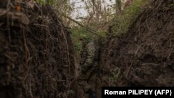 Український військовослужбовець 65-ї механізованої бригади йде в траншеї, збудованій російськими військами, біля прифронтового села Роботине Запорізької області, 1 жовтня 2023 року