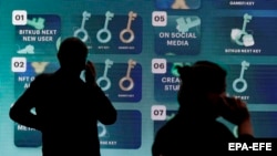 Posetioci ispred elektronske table na sajmu kriptovaluta u Bangkoku u maju.