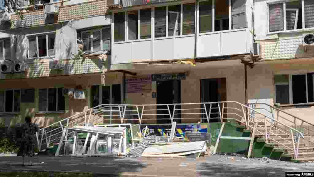 Женщина смотрит на поврежденное окно своей квартиры на втором этаже дома на улице Марченко. Эта улица пострадала в Новофедоровке больше всего, поскольку  находится на самом близком расстоянии от военного аэродрома