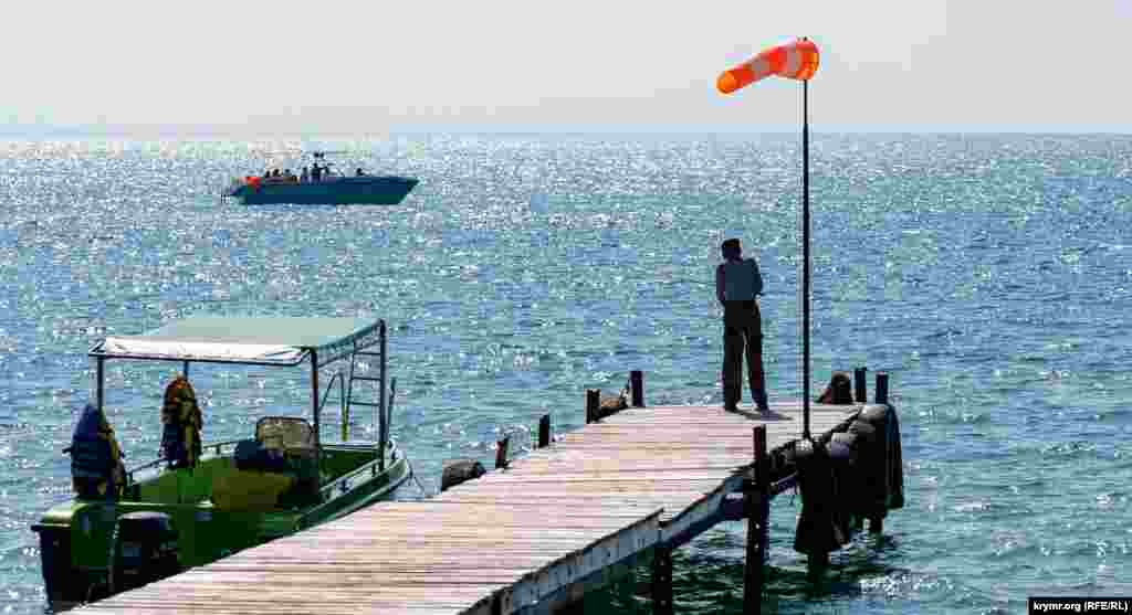 Рыбак на причале под «колдуном» – ветроуказателем