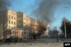 Розбитий танк і тролейбус горять на вулиці Грозного, столиці Чечні, під час боїв між підтримуваними Москвою бойовиками та чеченськими урядовими військами, 27 листопада 1994 року