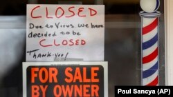 Написи «Продається власником» та «Закрито через вірус» на дверях магазину в місті Ґросс-Пойнт-Вуд у штаті Мічіґан, США, квітень 2020 року