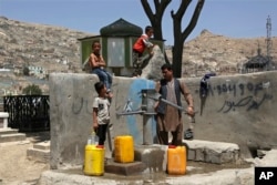 Muškarac i njegova djeca toče vodu s javne pumpe za vodu u Kabulu (fotoarhiv)
