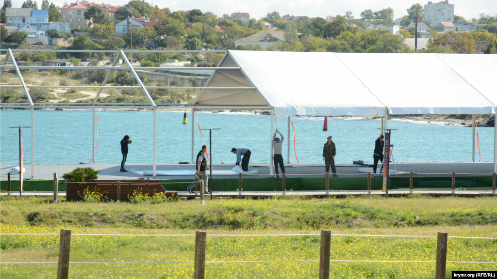 Рабочие разбирают «временное сооружение» – снимают синтетическое тентовое покрытие с арматуры