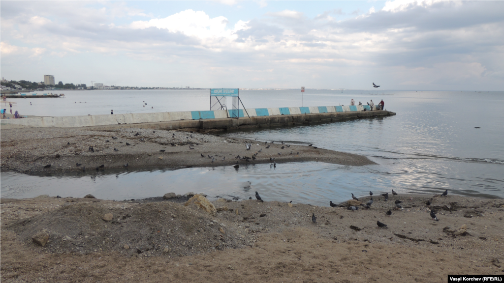 Канализационные стоки льются в море вблизи феодосийского пляжа, рядом прогуливаются взрослые и дети 